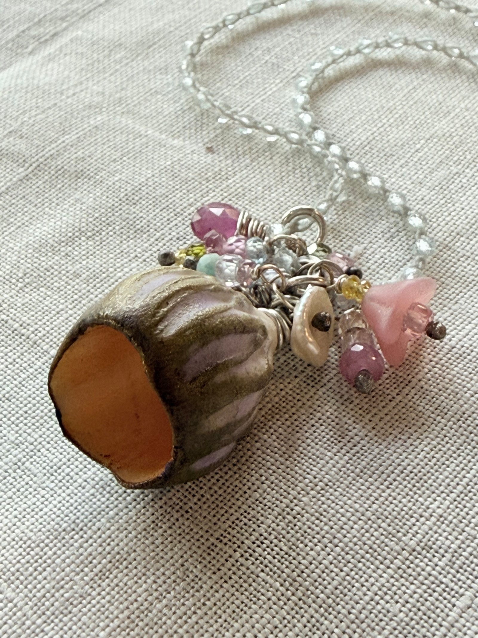 Hand-crocheted gemstone necklace with a sculptural silver vessel pendant