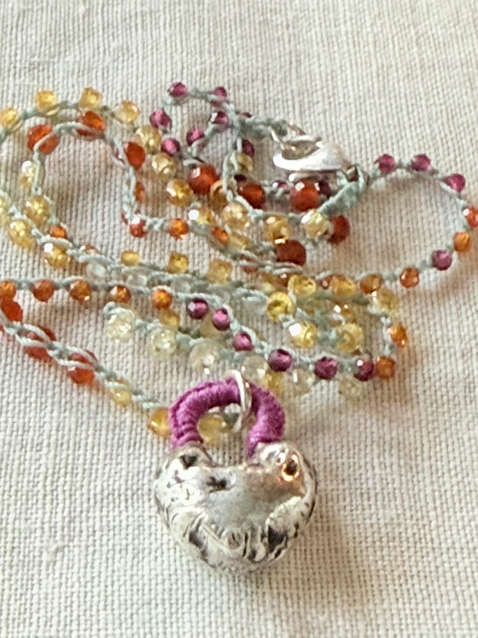 Hand-crocheted gemstone necklace with a sculptural silver rabbit pendant